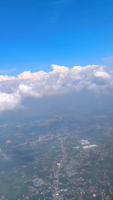 Bright blue sky with fluffy clouds, showing view of islands and cityscape below Video stock 312729790