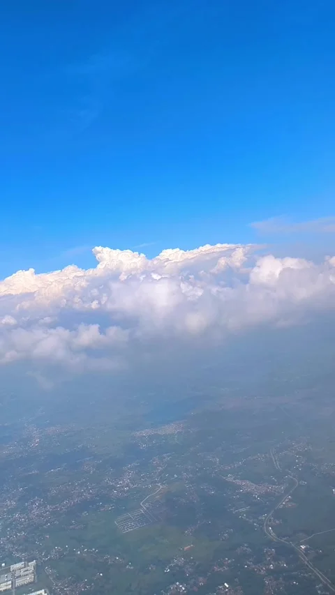 Bright blue sky with fluffy clouds, showing view of islands and cityscape below Video stock 312729814