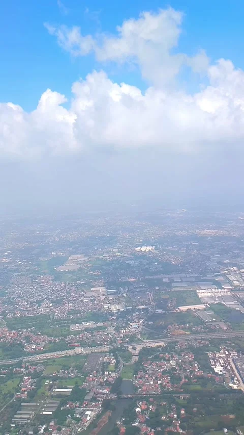 Bright blue sky with fluffy clouds, showing view of islands and cityscape below Video stock 312729976