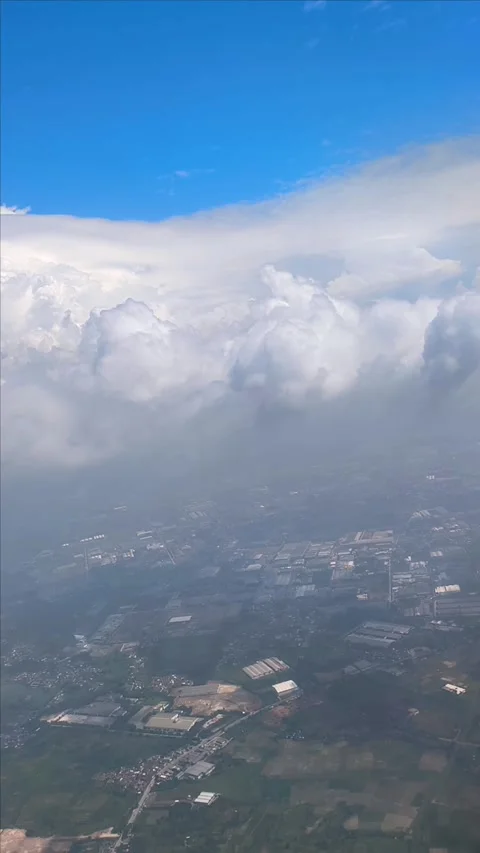 Bright blue sky with fluffy clouds, showing view of islands and cityscape below Video stock 312730281