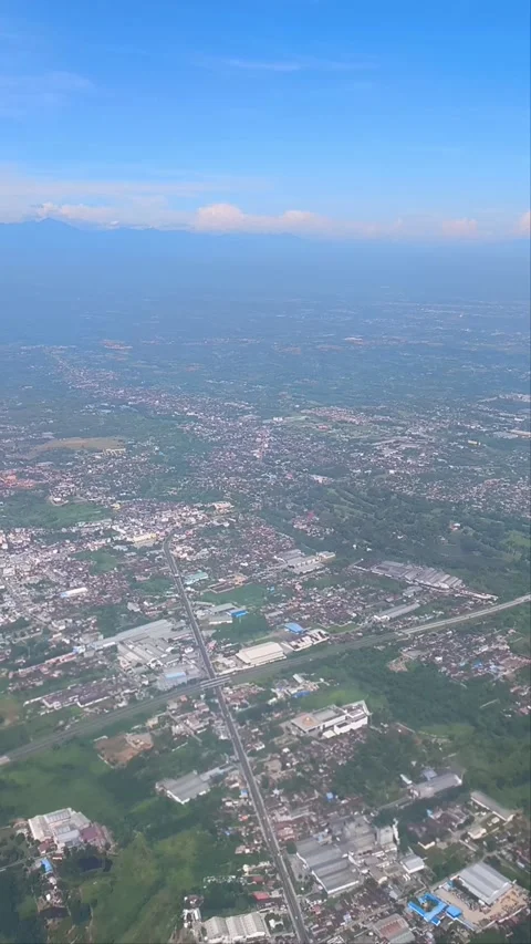Bright blue sky with fluffy clouds showing a view of islands and cityscape 库存影片 312730854