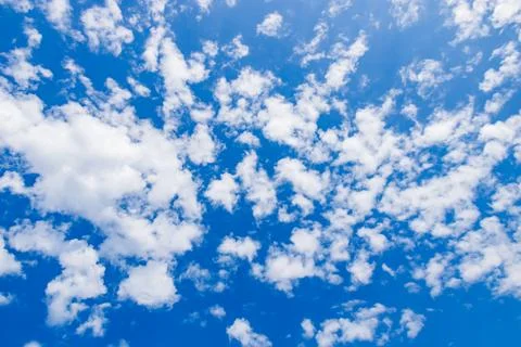 Bright blue sky with fluffy clouds scattered throughout a sunny day Stock Photos