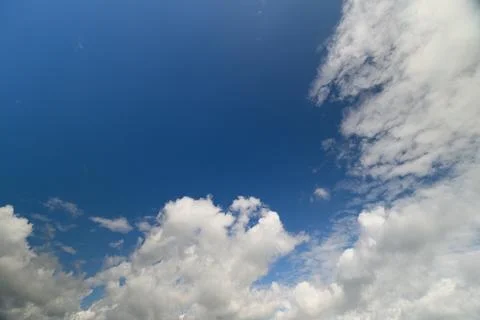 Bright blue sky with fluffy clouds floating gently during a sunny day in th.. Stock Photos