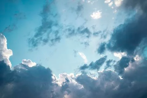 Bright blue sky with gray clouds. Sun rays. Horizontal photo. Photos