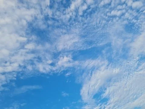 Bright Blue Sky with Scattered White Clouds Background 库存照片