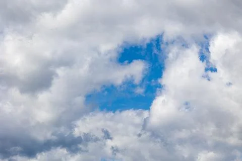 Bright blue sky is showing through cumulus clouds on cloudy day Stock Photos