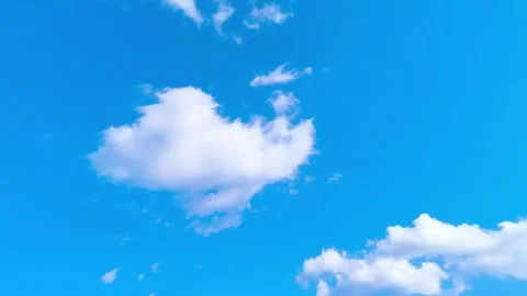 Bright blue sky with soft white clouds on a warm windy vibrant sunny summer day 動画素材 317135702