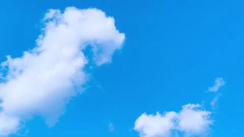 Bright blue sky with soft white clouds on a warm windy vibrant sunny summer day 動画素材 317135789