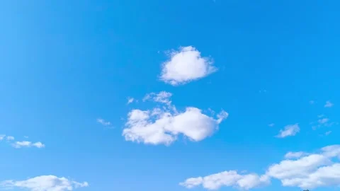 Bright blue sky with soft white clouds on a warm windy vibrant sunny summer day 動画素材 317135835