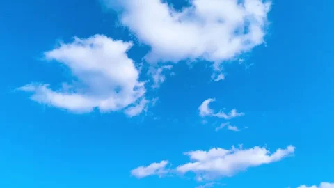 Bright blue sky with soft white clouds on a warm windy vibrant sunny summer day 動画素材 317136008