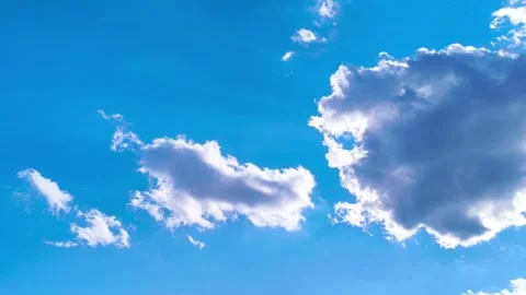 Bright blue sky with soft white clouds on a warm windy vibrant sunny summer day 動画素材 317136018