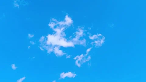 Bright blue sky with soft white clouds on a warm windy vibrant sunny summer day 動画素材 317136126