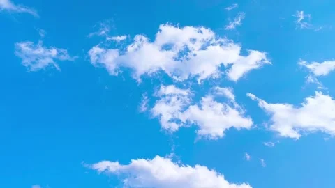 Bright blue sky with soft white clouds on a warm windy vibrant sunny summer day 動画素材 317136260