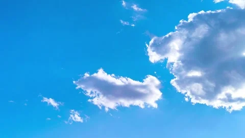 Bright blue sky with soft white clouds on a warm windy vibrant sunny summer day 動画素材 317136265