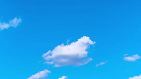 Bright blue sky with soft white clouds on a warm windy vibrant sunny summer day 動画素材 317136346