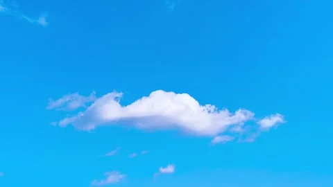 Bright blue sky with soft white clouds on a warm windy vibrant sunny summer day 動画素材 317136394