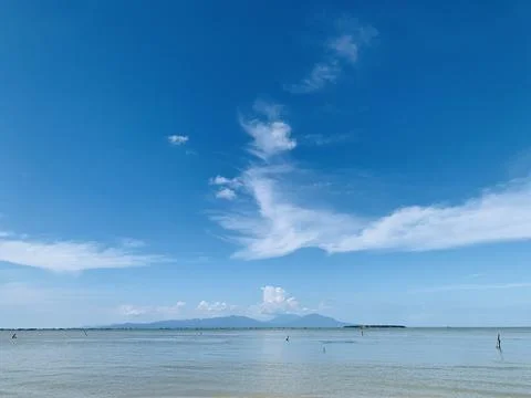 Bright Blue Sky with Soft White Clouds at Tanjung Lesung Beach Stock Photos