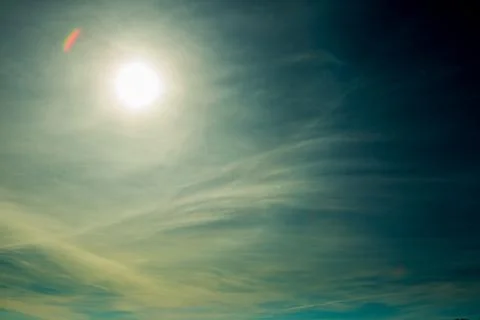 Bright blue sky with the sun causing lens flare Stock Fotos