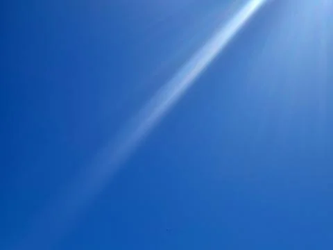 Bright blue sky with sun rays and lens flare Stock Photos