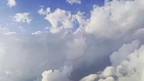 Bright blue sky with towering white cumulus clouds, soft sunlight, broad open Stock Footage 345437308
