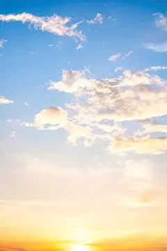 Bright blue sky with white clouds and warm sunset Stock Photos