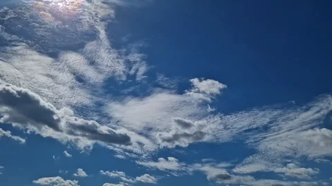Bright blue sky with white fluffy clouds and sunlight Stock Footage 345329382