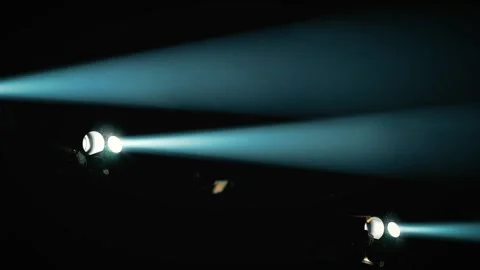 Bright blue stage spotlights shining horizontally through smoke Stockbeeldmateriaal 346332403