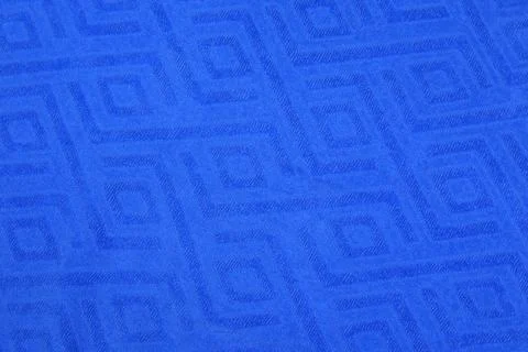 Bright blue textile surface with embossed geometric square patterns in a seamles Stock Photos