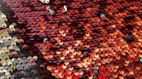Bright blurry background of red sequin scales with golden glares Stock Photos