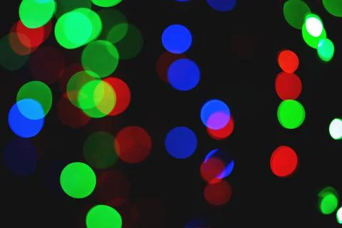 Bright bokeh on a black background. Background random composition. Defocused Stock Photos