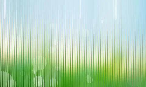 Bright bokeh light background distorted behind a green vertical fluted glas.. Stock Photos