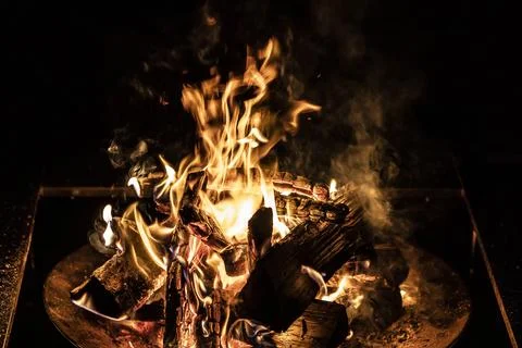 Bright Bonfire Burning with Dynamic Orange Flames on Black Background Stock Photos