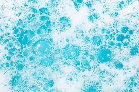 Bright bubbles create a vibrant texture in blue water with a foamy appearance Stock Photos