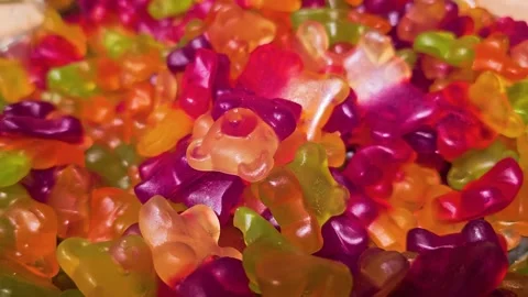 Bright bulk candy display with assorted gummy bears, translucent fruit colors Stock Footage 340901211
