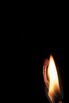 Bright burning match on a black background, shot close-up. Stock Photos