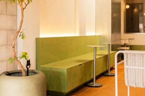 In a bright cafe space, green seating and small tables create a simple and in Stock Photos