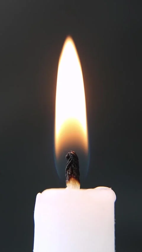 Bright candle flame close-up on a black background. The wick is smoking. Stock Footage 237202028