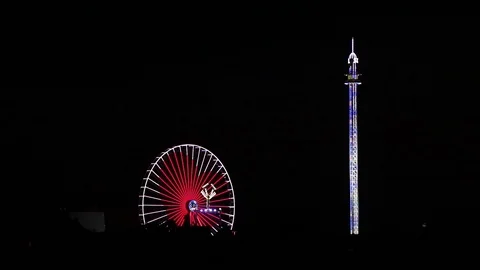 Bright carnival ferris wheel displaying a red heart for love at a festival Stock Footage 96996652
