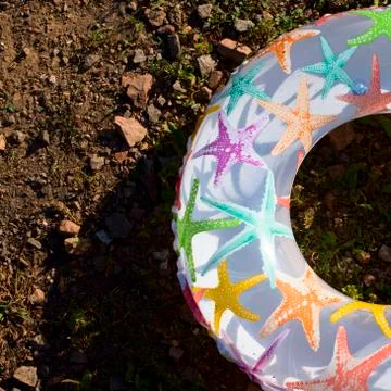 Bright children's inflatable circle lying on the ground on the beach Lifeline is Stock Photos