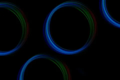 Bright circles of light create dynamic trails in vivid colors, set against a  Stock-Fotos