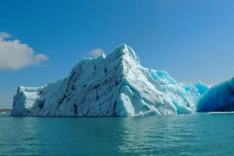 Bright clear blue iceberg floating in the Jokulsarlon lake blue cold water .. Stock Photos