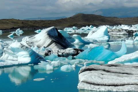 Bright clear blue iceberg floating in the Jokulsarlon lake blue cold water .. Stock Photos