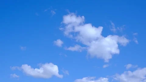 Bright, clear blue sky with scattered white clouds, including a large fluffy Stock Footage 343781175