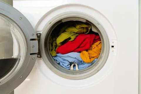 Bright clothes inside washing machine. Stock Photos