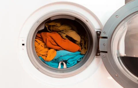 Bright clothes inside washing machine. Stock Photos