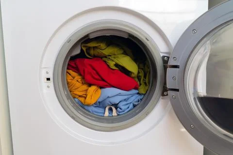 Bright clothes inside washing machine. Stock Photos