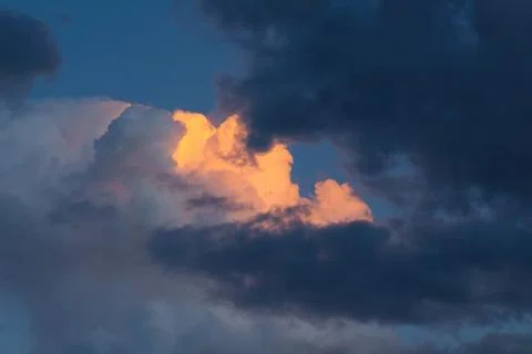 Bright cloud surrounded by storm clouds. Stock Photos
