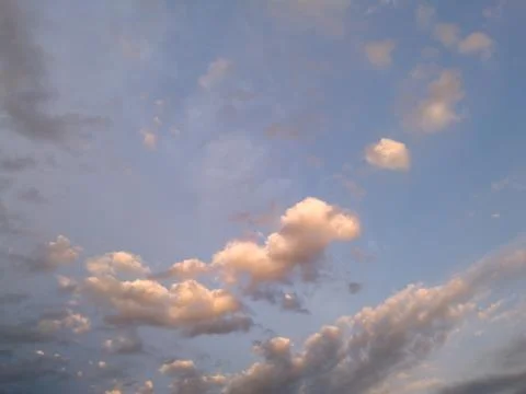 Bright clouds in the blue sky during the evening. Abstract pattern in nature. Stock Photos