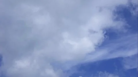 Bright clouds drift slowly across the vast blue horizon forming a poetic motion Video stock 324625380