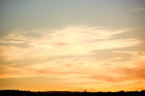 	 Bright clouds lit by the setting sun which has dropped below the horizon ..	 Stock Photos